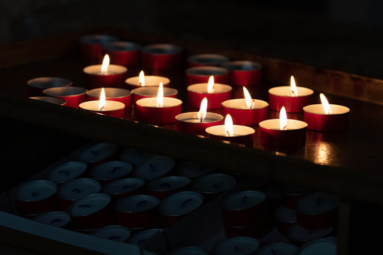 lumini rossi , candele religiose con fiamma in ambiente scuro