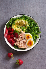 Tuna strawberries avocado egg and spinach salad. Tuna fish salad. View from above, top studio shot