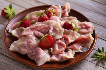 Dumplings, filled with strawberries. Varenyky, vareniki, pierogi, pyrohy - dumplings with filling
