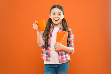 Fueled for school. Small girl enjoying her school break on orange background. Happy schoolgirl...