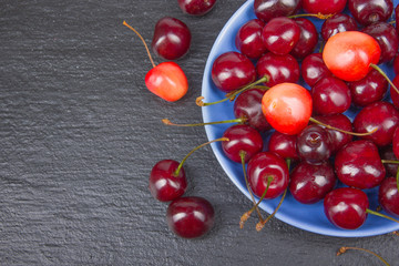 Various summer Fresh Cherry in a bowl on rustic wooden table. Antioxidants, detox diet, organic fruits. Top view. Berries
