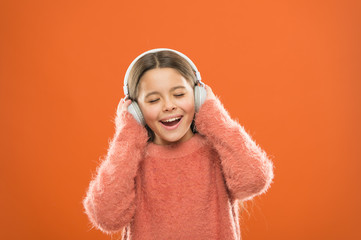 Enjoy sound. Girl cute little child wear headphones listen music. Kid listen music orange background. Recommended music based on initial interest. Best free music apps for your mobile device