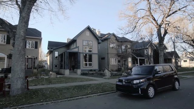 View down a street of an established neighbourhood with houses and large trees; Edmonton, Alberta, Canada