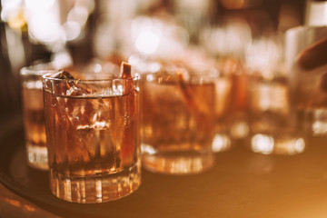 A close up shot of whisky based cocktails with ice cubes on the bar. Fine alcohol, beverage and...