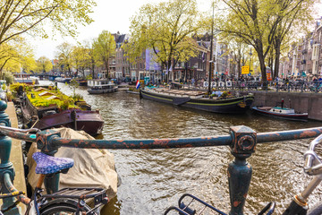 Fototapeta na wymiar AMSTERDAM, NETHERLANDS - APRIL 13, 2019: Bicycles lining a bridge over the canals of Amsterdam