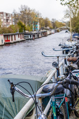 AMSTERDAM, NETHERLANDS - APRIL 13, 2019: Bicycles lining a bridge over the canals of Amsterdam