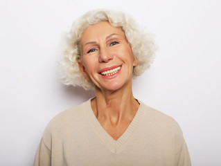 Fototapeta na wymiar lifestyle, emotion and people concept: Close up portrait of happy senior woman smiling