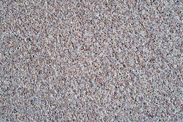 Texture of small stones. Background in the form of polished stones of gray, black, white and brown colors.