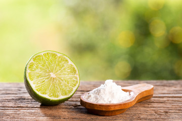 Baking soda with lemon. Wooden table in the park among the trees on a summer day. Text space