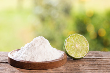 Baking soda with lemon. Wooden table in the park among the trees on a summer day. Text space
