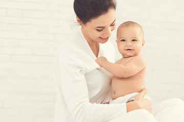 Young mother hugging her cute newborn child