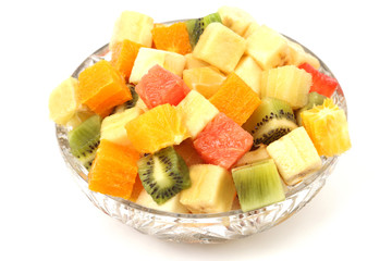 slices of different fruits in the form of cubes in a plate on white background