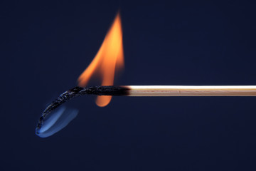 burning and Smoking wooden match on dark background.