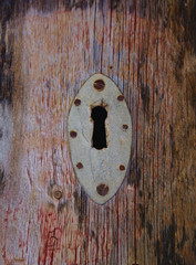 Old corroded keyhole on wooden door