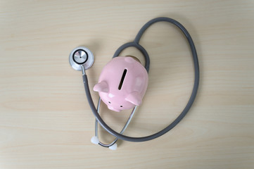 Piggy bank with stethoscope  financial checkup or saving for medical insurance costs