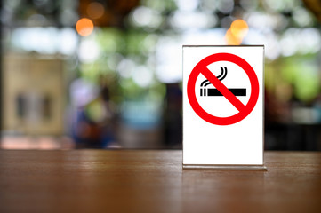 no smoking sign with shopping place background on wooden table