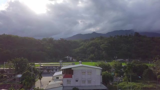 Aerial view of rice fields in Yuli, Hualien County, Taiwan. The area is located in the eastern rift valley, surrounded by layers of mountains. - crane up