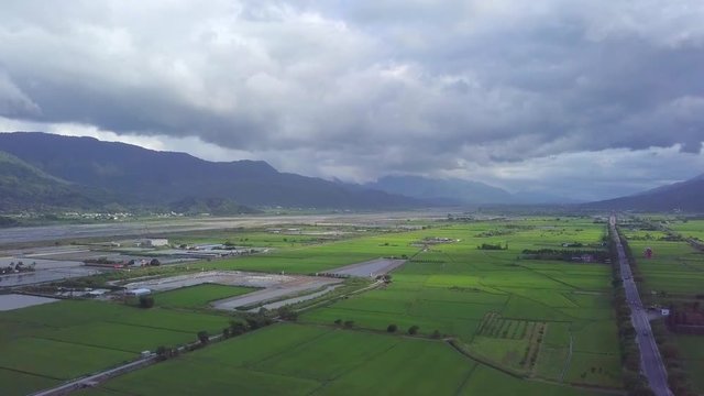 Aerial view of rice fields in Yuli, Hualien County, Taiwan. The area is located in the eastern rift valley, next to the famous Xiuguluan River, surrounded by layers of mountains. - Fly forward