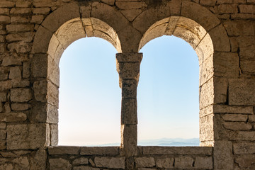 Two windows in an old tower or fortress, view from the inside.