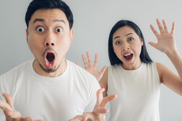 Surprised and shocked couple lover in white t-shirt and grey background.
