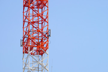 Closeup of square cylinder tower with antenna installed and clear blue sky background
