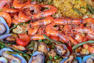 Spanish seafood paella in fry pan with mussels, shrimps and vegetables. Seafood paella background, closeup, traditional spanish rice dish