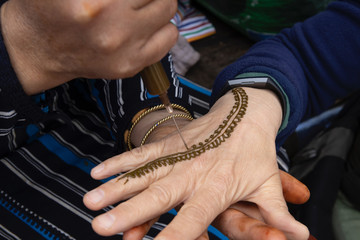 A Henna artist applies her trade to a client in Chefchaouen, Morocco