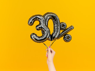 Thirty percent symbol discount. 30 % sale banner black flying foil balloons on yellow. 3d rendering.