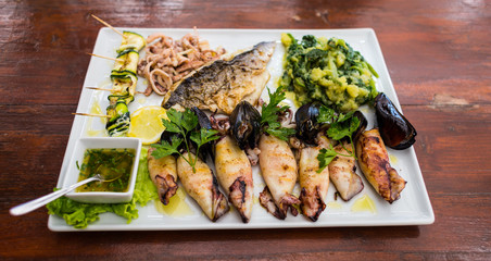 Squids, mussels and octopus with grilled vegetables and sauce.
