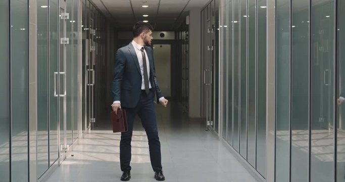 Funny Caucasian manager dancing in office hall, celebrating his success. Businessman cheering after having an achievement - way to success concept 4k