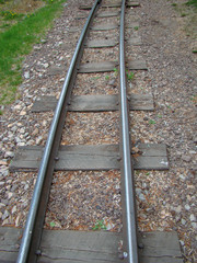 Naklejka premium Path narrow-gauge railway. Iron rails, wooden sleepers. Gravel. Fertic Photo.