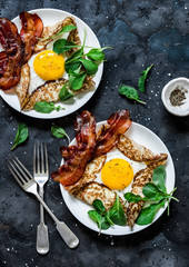 Stuffed egg crepes with bacon and arugula - delicious nutritious brunch on a dark background, top view. Flat lay
