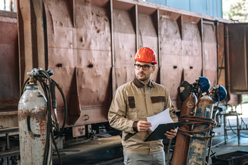 Portrait of a handsome man working at train factory.