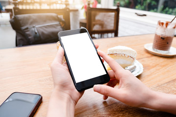Mockup image of a man holding mobile phone with blank black screen in modern loft cafe