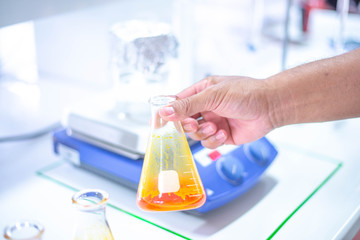 Hands are experimenting using laboratory equipment.