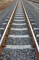 Steel support rails with concrete sleepers strewn with gravel 