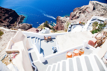 beautiful Oia town on Santorini island, Greece. Traditional white architecture and greek orthodox churches with blue domes over the Caldera, Aegean sea. Scenic travel background