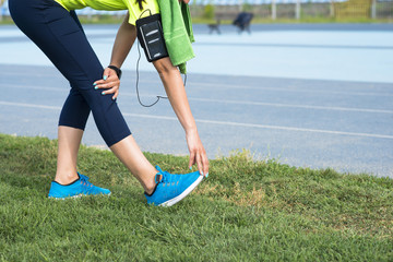 Young woman stretching legs after running outdoor