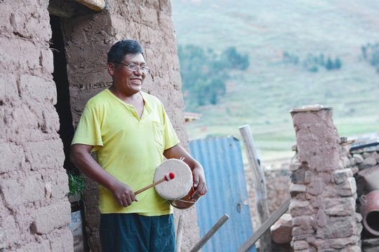 Native american man playing typical sikuri drums.