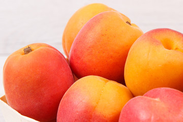 Naklejka na ściany i meble Apricot or peach in wooden box as healthy snack or dessert. Food containing vitamins and minerals