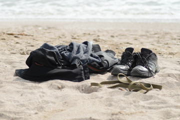 portrait of male clothes and leash with collar from a dog on the beach against the sea
