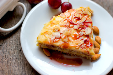 Delicious, creamy almond cake on white plate close-up