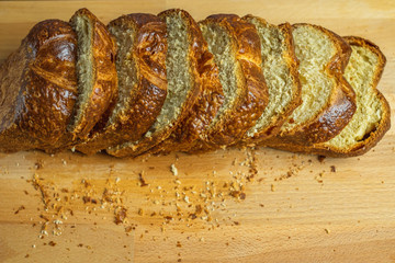 Sliced Brioche toast loaf with bread crumbs on wood cutting board