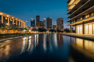 The downtown Los Angeles skyline at night, with the reflecting pool at the Department of Water and...
