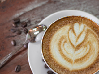 Cup of coffee and coffee beans on wooden table