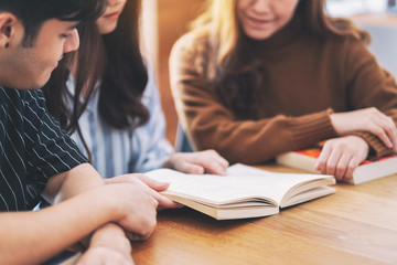 Group of young people enjoyed reading the same book togetherGroup of young people enjoyed reading...