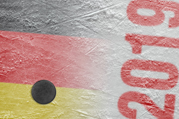 Hockey puck lying on the ice of the arena with the image of the German flag
