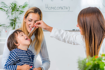 Homeopathy. Mother and little boy visiting a homeopath