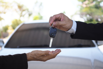 The car salesman and the key to the new owner.