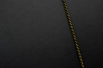 Fototapeta na wymiar copper chain on a black background minimalism
